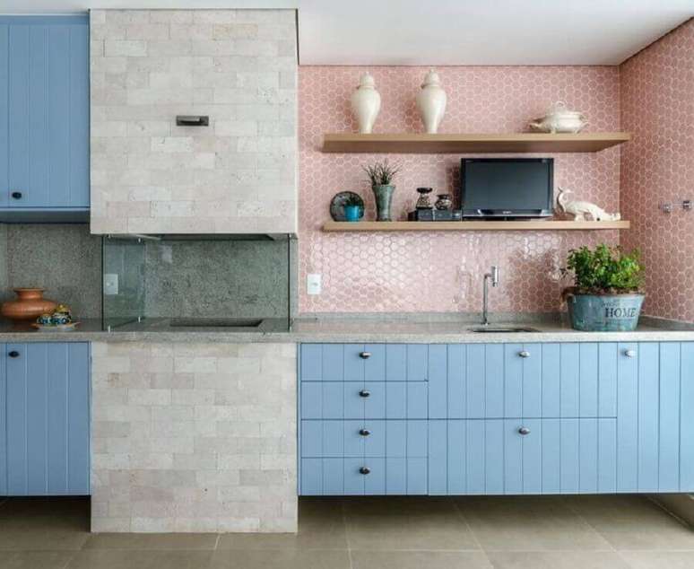 3. Revestimento cor de rosa chá para varanda gourmet decorada com armário azul e churrasqueira de vidro – Foto: Andrea Murao
