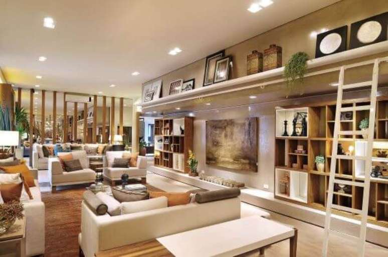 55. Sala grande decorada com estante planejada e prateleira decorada com quadros e enfeites variados &ndash; Projetos Quitete e Faria