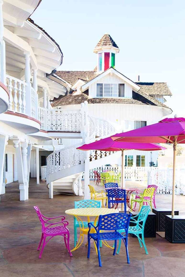 8. Guarda sol para piscina em cor de rosa com mesas e cadeiras coloridas – Foto Pinterest