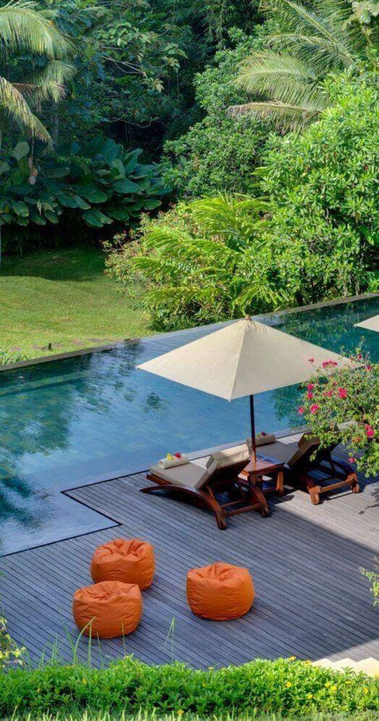 41. Guarda sol para piscina com espreguiçadeira e deck de madeira – Foto Casa Tres Chic