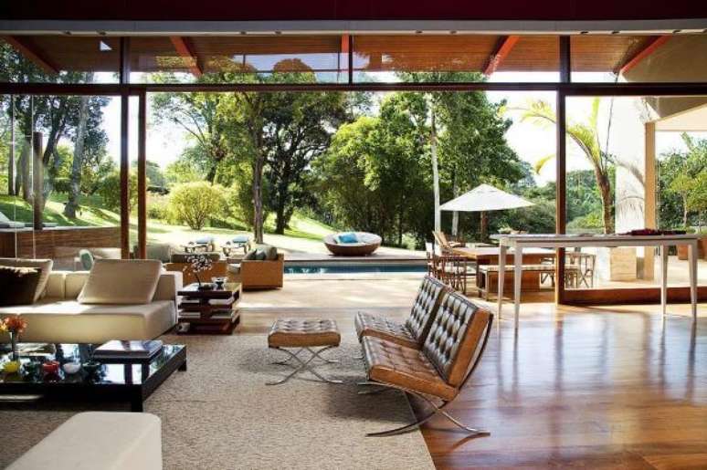 64. Sala grande decorada com móveis de couro e abertura para piscina – Projeto Fernando Piva