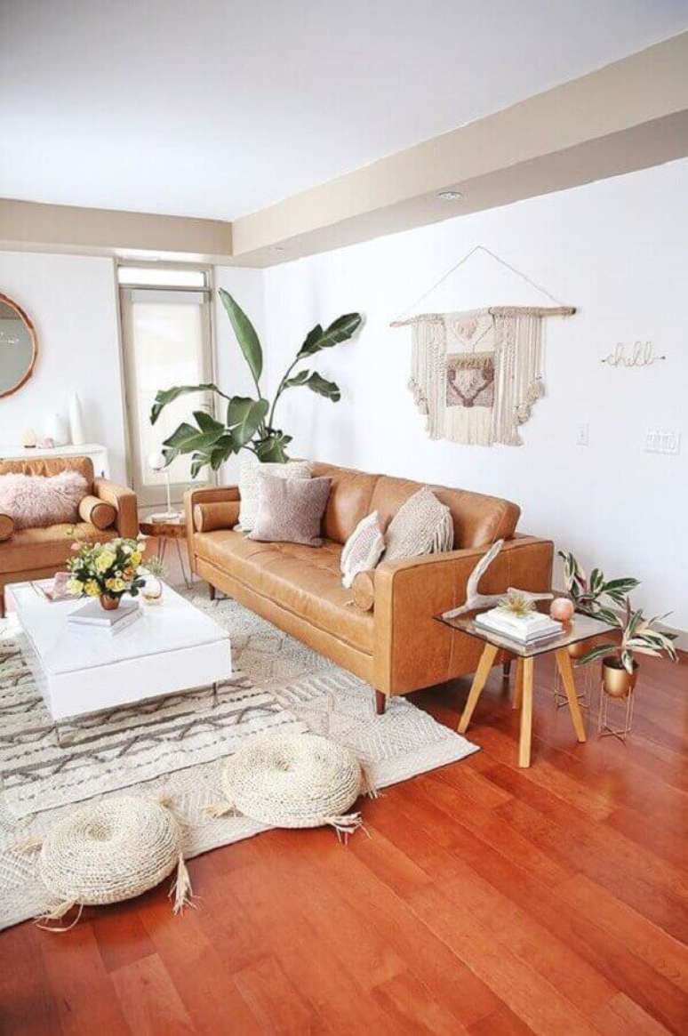 11. Sala grande decorada com chão de madeira sofá caramelo e plantas – Foto Casa de Valentina