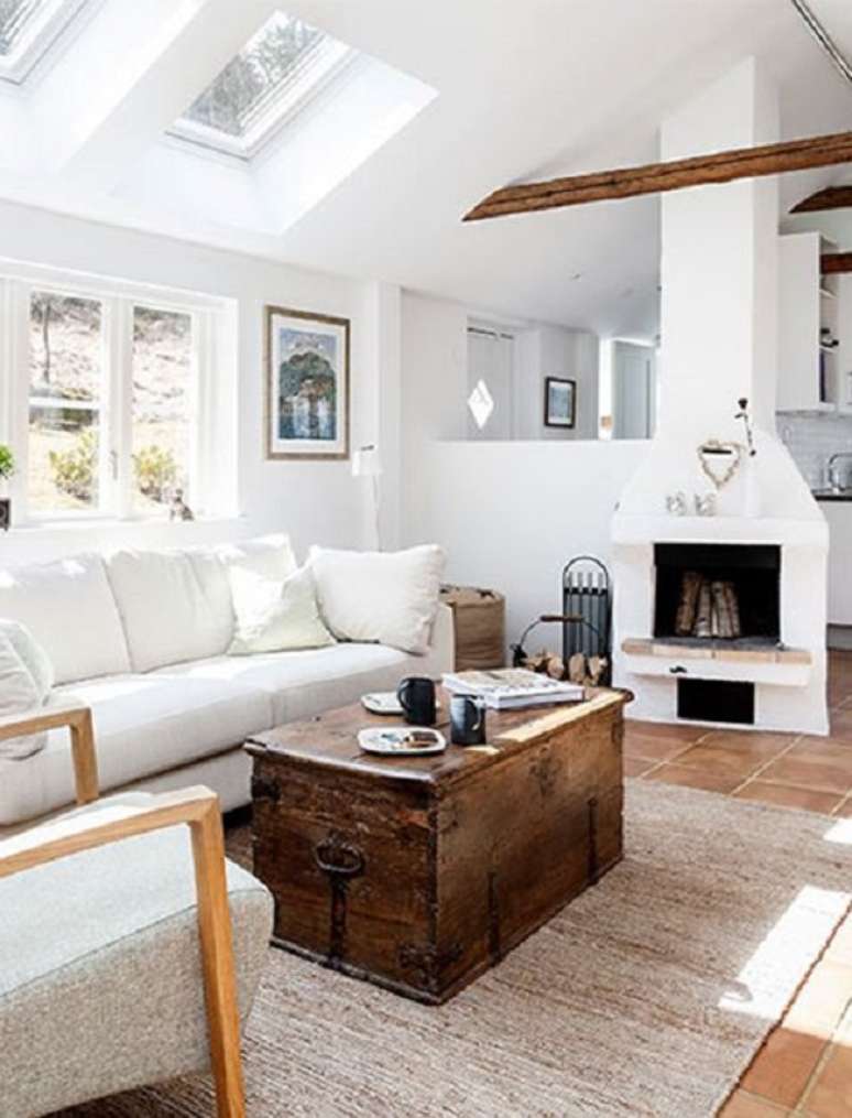 40. Sala com lareira e ba&uacute; de madeira e tapete bege &ndash; Foto Pure Wow