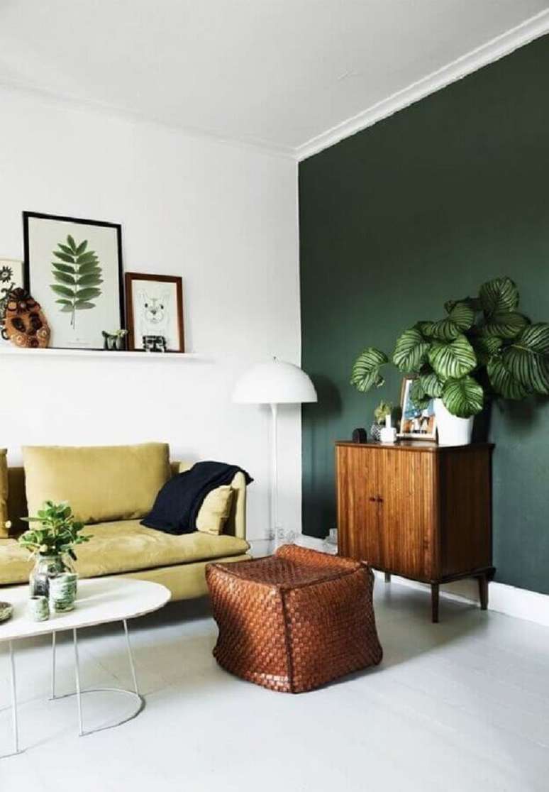 2. Decoração de sala de estar com parede verde e armário de madeira pequeno – Foto: Homedit
