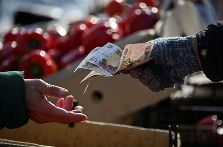Vendedor devolve notas de rublo a consumidor em mercado de rua de Omsk, na Rússia
31/03/2021
REUTERS/Alexey Malgavko