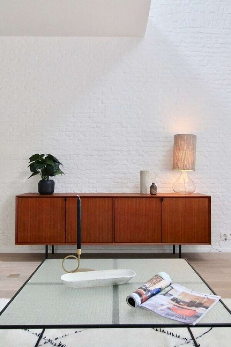 24. Buffet de madeira para sala minimalista decorada com parede de tijolinho branco &ndash; Foto: Apartment Therapy