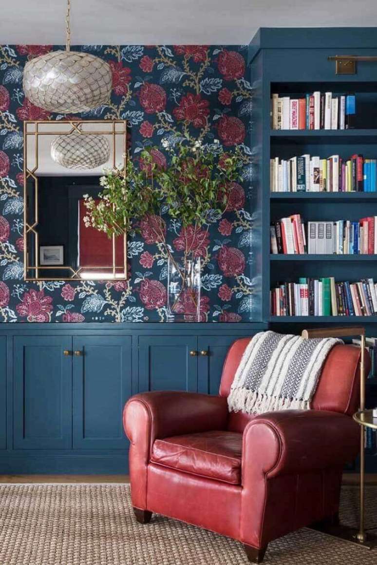 57. Poltrona vermelha de couro para sala decorada com papel de parede floral – Foto: Pinterest