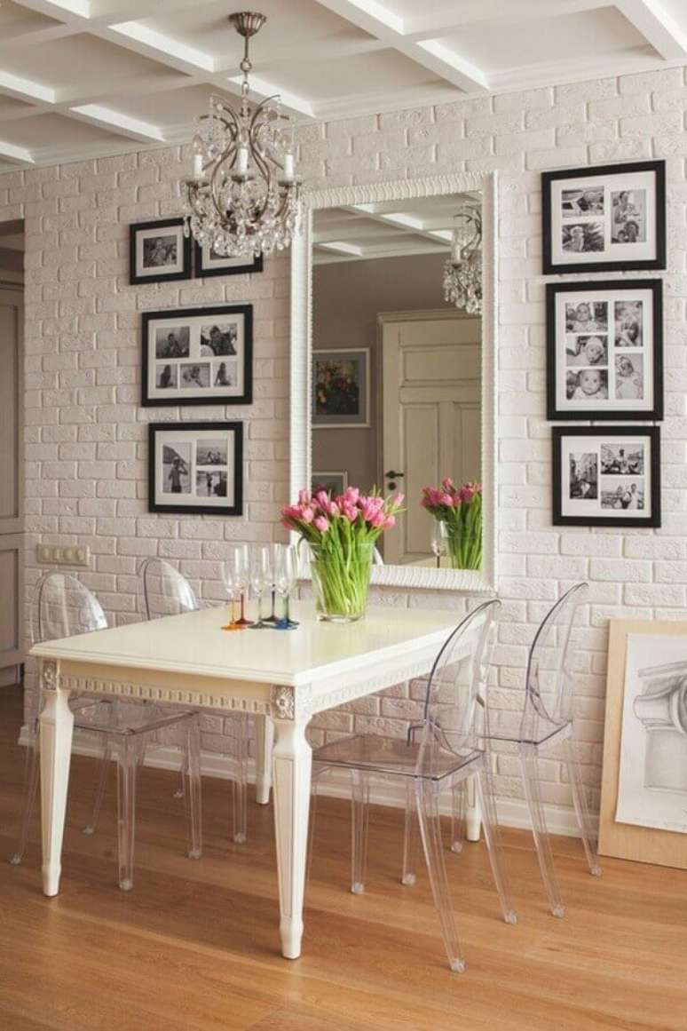 31. Objetos de decoração para sala de jantar branca com cadeiras transparentes e espelho de parede – Foto: FresHOUZ