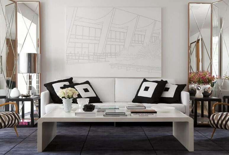 57. Objetos para decoração de sala com espelho grande e almofadas para sofá branco – Foto: Beto e Norea