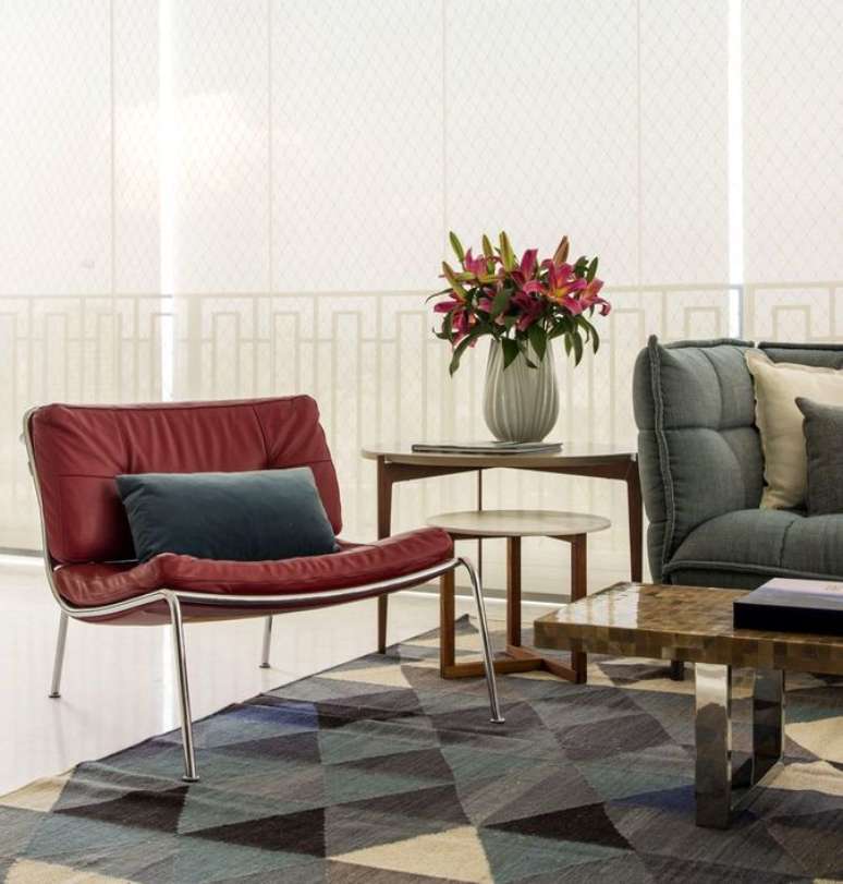 37. Esta poltrona vermelha usa uma tonalidade mais s&oacute;bria. Projeto de Mar&iacute;lia Veiga