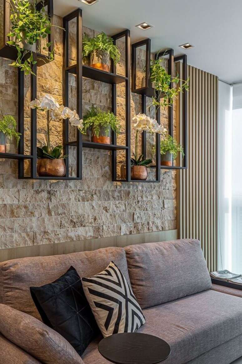 4. Objetos de decoração para sala com parede rústica e vasos de plantas e prateleira industrial – Foto: Jeito de Casa