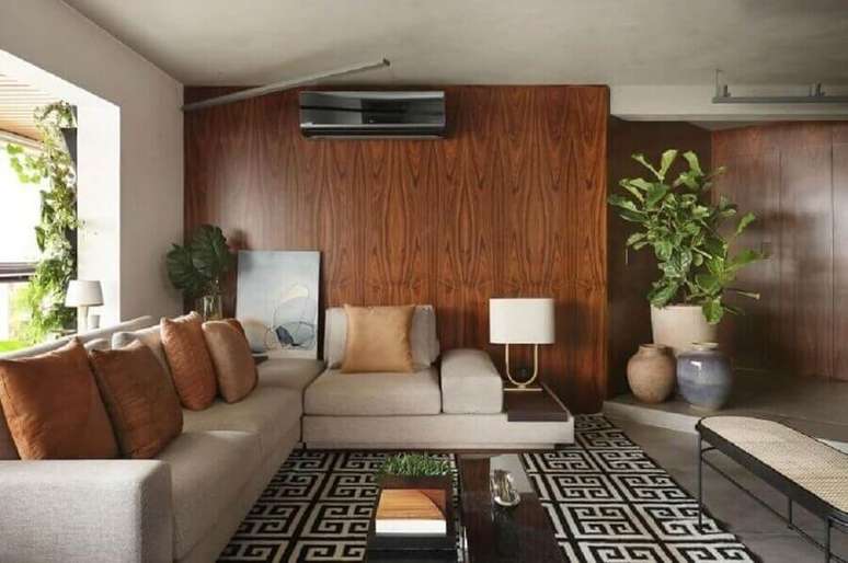 30. Objetos de decoração para sala de estar com tapete geométrico e parede de madeira – Foto: Quattrino Arquitetura