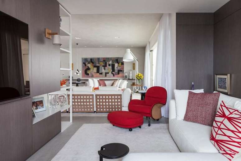 44. As almofadas desta sala combinam com a poltrona vermelha. Projeto de Oleg&aacute;ria de S&aacute; & Gilberto Cioni