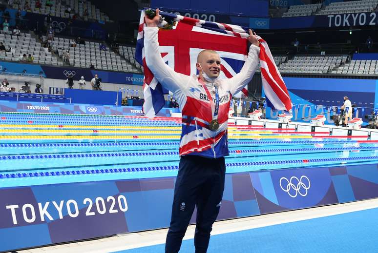 Adam Peaty segura a bandeira da Inglaterra na comemoração do ouro Kai Pfaffenbach/Reuters