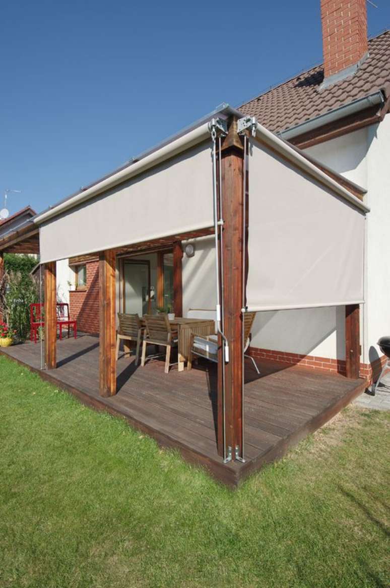 43. Toldo vertical para varanda com móveis de madeira para proteger o espaço da chuva e sol – Foto Ebarch