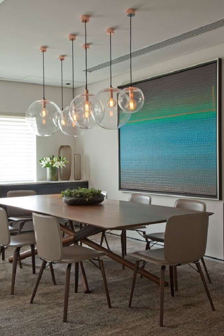 41. Luminária de vidro para sala de jantar decorada com quadro grande – Foto: Casa de Valentina