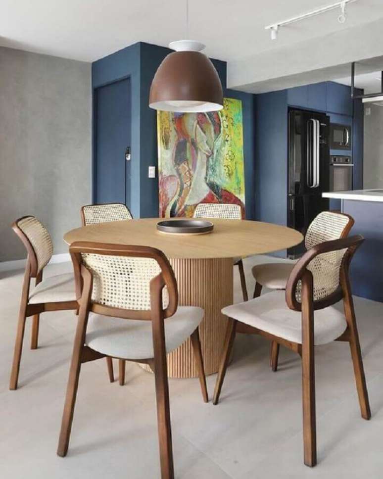 34. Luminária de teto para sala de jantar decorada com mesa redonda e cadeira de palhinha – Foto: Pinterest