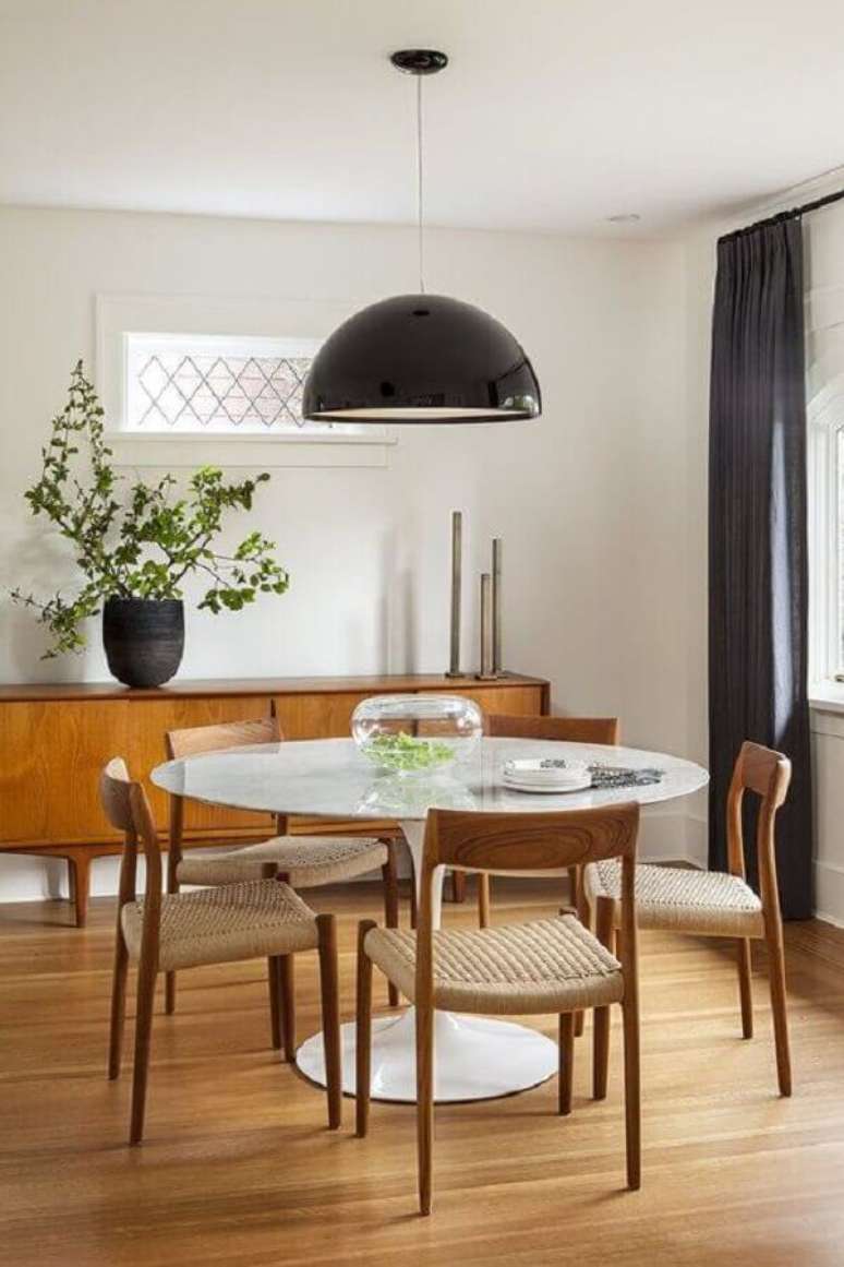 13. Buffet de madeira e luminária de teto para sala de jantar decorada com mesa redonda – Foto: Scout & Nimble