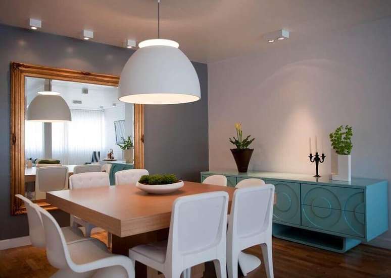 46. Luminária para sala de jantar cinza decorada com espelho grande e buffet azul – Foto: Ih Designers