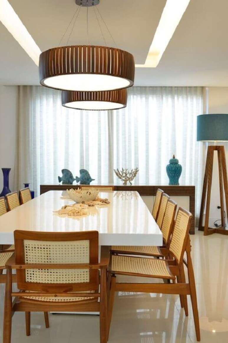 62. O acabamento em madeira da luminária para sala de jantar se harmonizou com os móveis do ambiente. – Foto: Homify