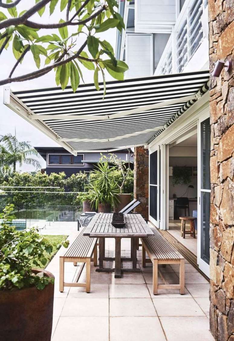 12. Toldo para varanda com mesa de madeira na área externa – Foto Homesto love