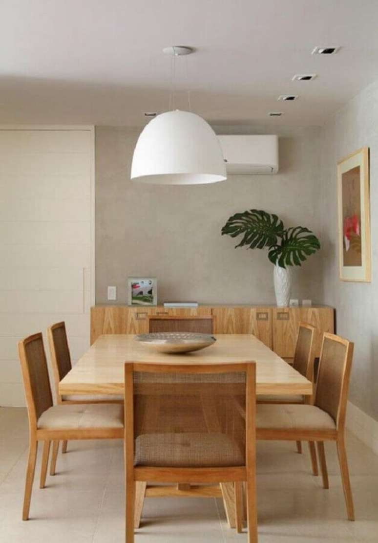 35. Luminária de teto para sala de jantar decorada com parede de cimento queimado e móveis de madeira – Foto: Jeito de Casa