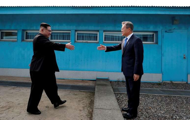 Líder norte-coreano Kim Jong Un e presidente da Coreia do Sul, Moon Jae-in se cumprimentam em vila na zona desmilitarizada entre os dois países
27/04/2018 Korea Summit Press Pool/Pool via Reuters