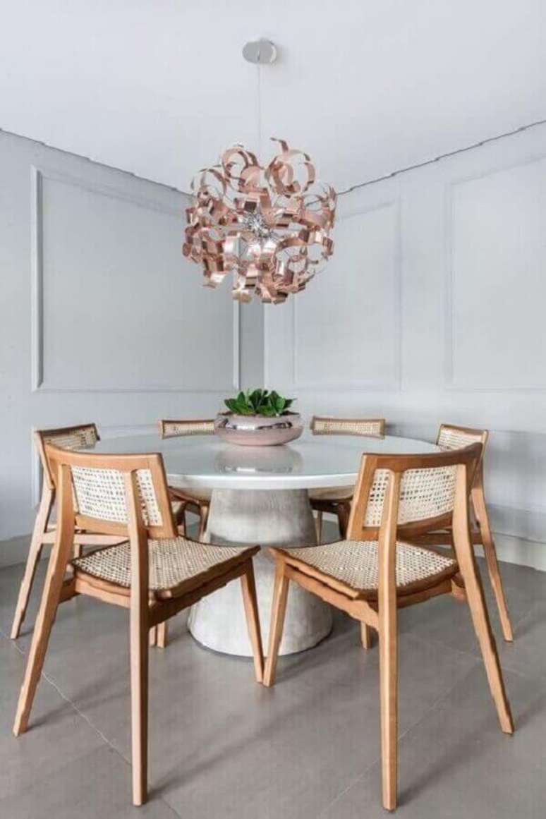 53. Luminária para sala de jantar moderna decorada com mesa redonda e cadeira de madeira – Foto: Pinterest