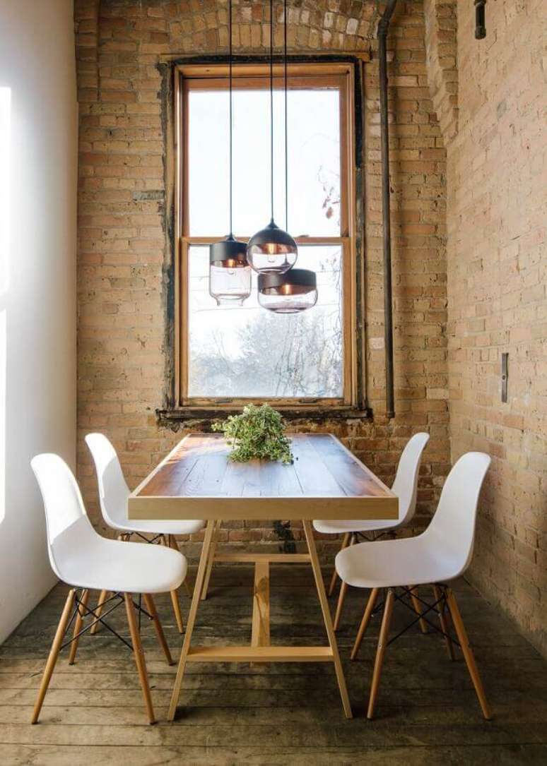57. Luminária para sala de jantar pequena e rústica decorada com cadeira eames branca e parede tijolinho – Foto: South Central