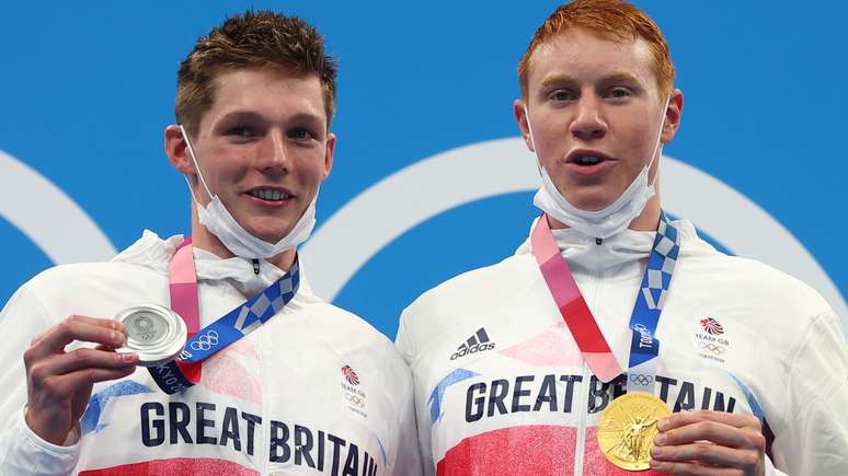 Tom Dean e Duncan Scott, da Inglaterra, festejam ouro e prata no pódio da natação em Tóquio Kai Pfaffenbach Reuters