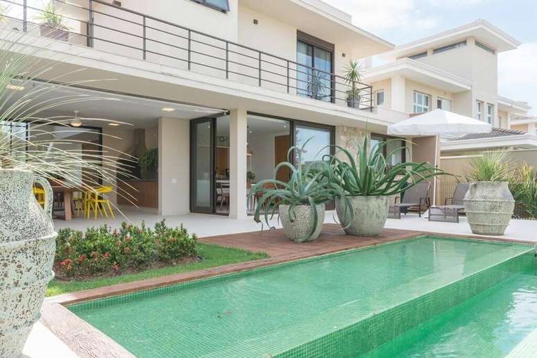 2. &Aacute;rea externa com porta deslizante e piscina pastilha verde. Projeto de Jannini Sagarra Arquitetura