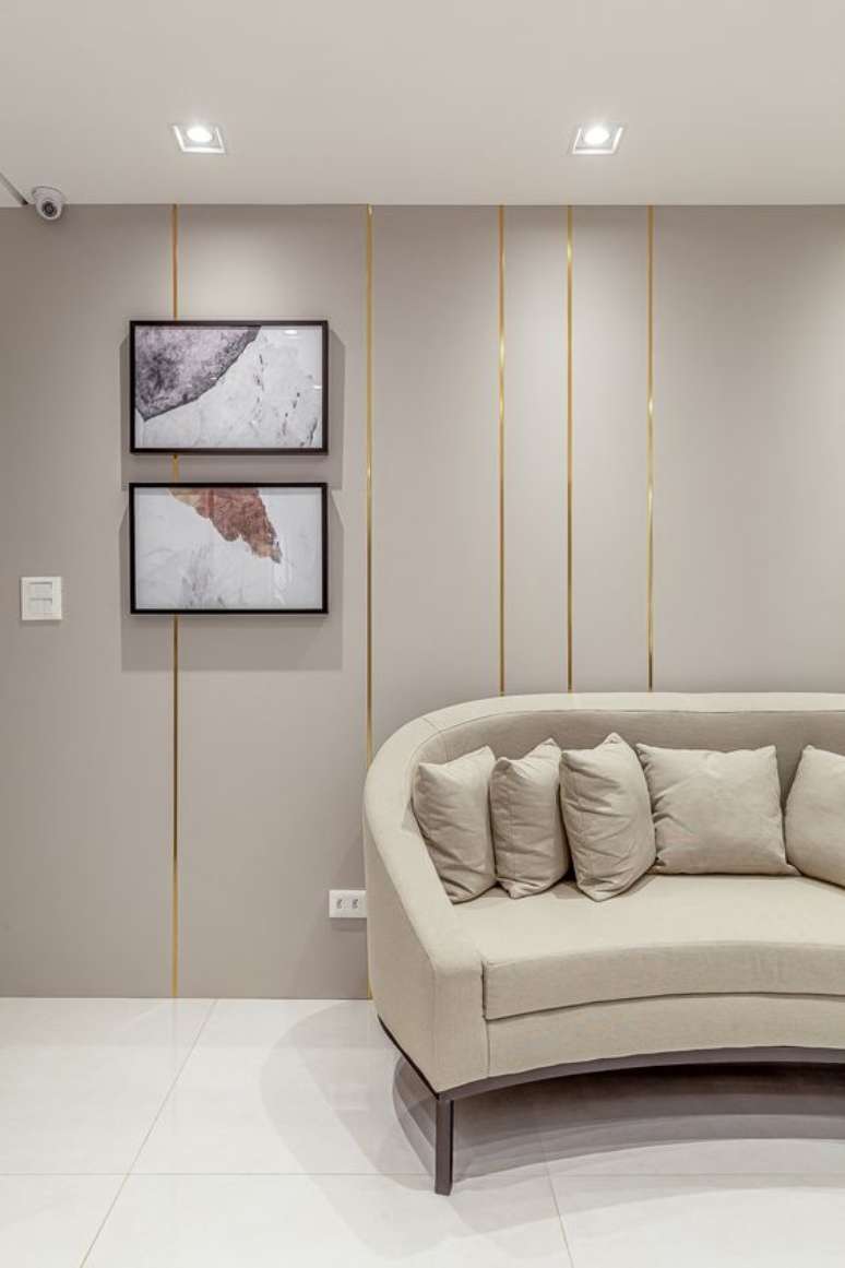 61. Sala de espera chique com sofá redondo bege e papel de parede dourado -Foto RPGuimarães