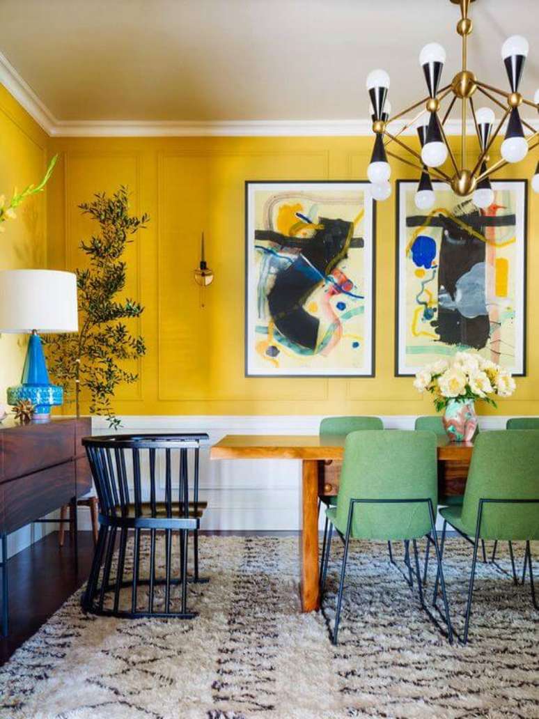 77. Sala de jantar grande decorada com tons de amarelo com cadeira retrô verde – Foto Casoca