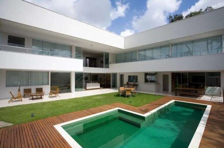 44. Portas de correr de vidro e piscina verde esmeralda decoram a &aacute;rea externa. Projeto de Ricardo Abreu Arquitetos