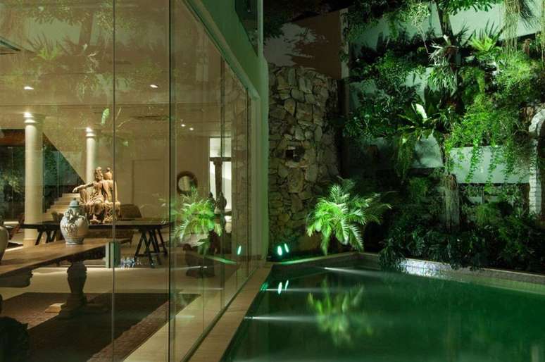 24. A ilumina&ccedil;&atilde;o noturna real&ccedil;a o azulejo de piscina verde. Projeto de Di Pace e Di Pace Arquitetura e Interiores