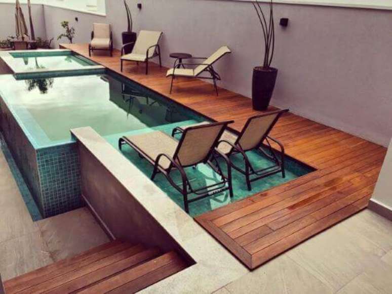 43. Piscina verde elevada com deck de madeira e espregui&ccedil;adeira. Fonte: Pinterest