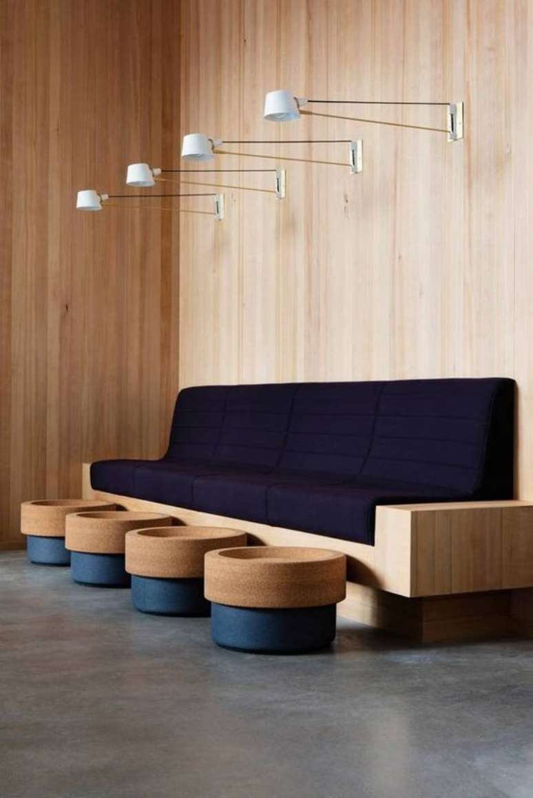 60. Sala de espera com sofá azul marinho e estrutura de madeira – Foto Domino Magazine