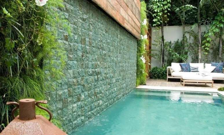 41. Piscina com azulejo verde e jardim vertical decoram a &aacute;rea externa do im&oacute;vel. Projeto de Andr&eacute; Arquimagens