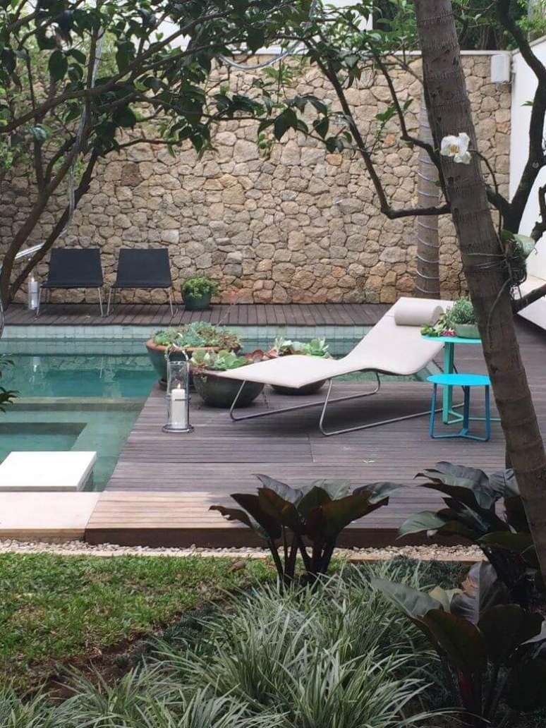 30. Muro revestido com pedras e piscina com azulejo verde. Projeto de Cat&ecirc; Poli Paisagismo