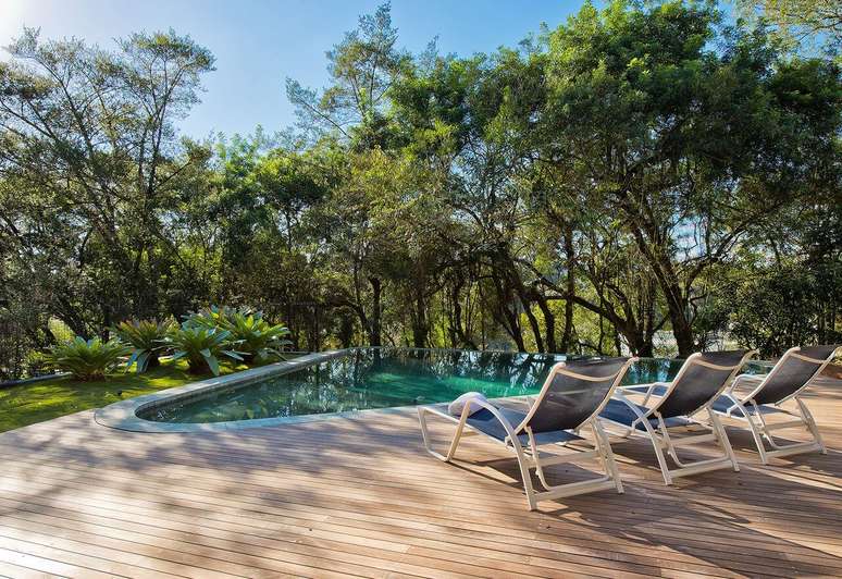 38. O revestimento verde para piscina com borda infinita se mistura com a vegeta&ccedil;&atilde;o. Projeto de Leonardo Muller