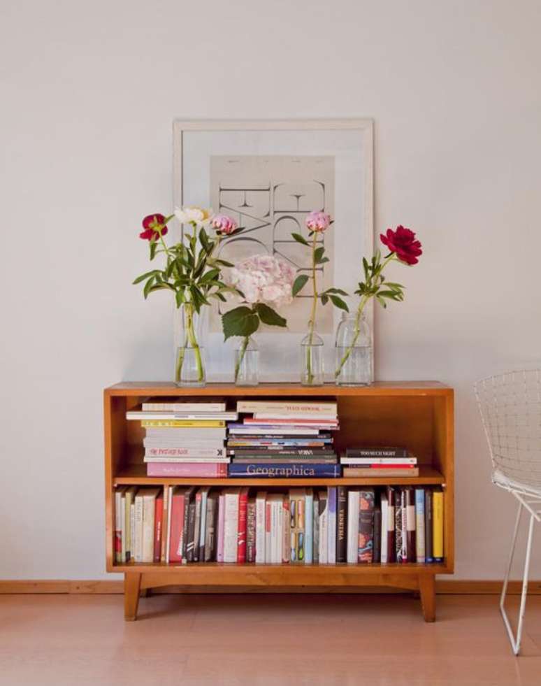 18. Parede de sala pequena decorada com quadros e uma mini estante de livros – Foto casa de Valenitna