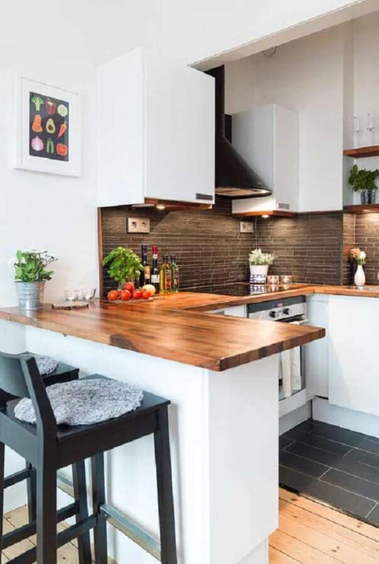 32. Cozinha estilo americana em U decorada com armários brancos e bancada de madeira – Foto: Home Fashion Trend