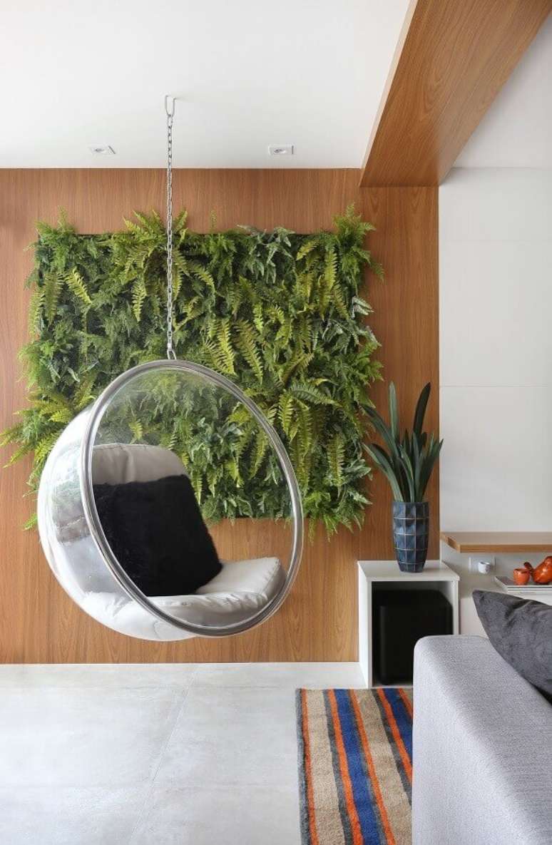 30. Cadeira de balan&ccedil;o suspensa para varanda decorada com jardim vertical &ndash; Foto: R&uacute;bia M. Vieira Interiores
