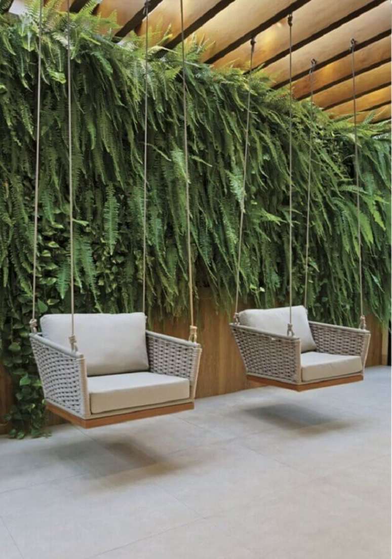 8. Cadeira de balanço moderna suspensa para decoração de varanda com jardim vertical – Foto: Revista InterArq