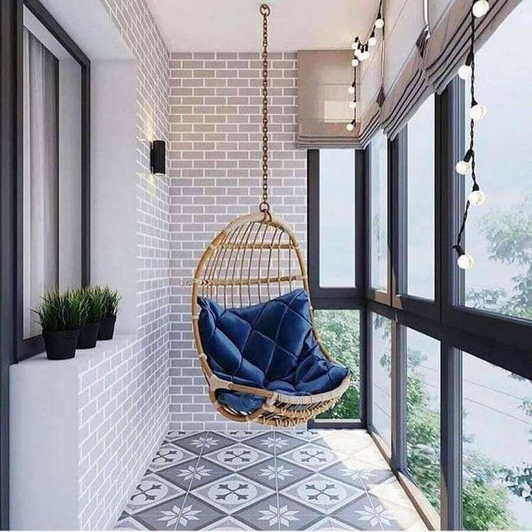 31. Cadeira de balanço suspensa para varanda pequena decorada com piso antigo – Foto: Pinterest