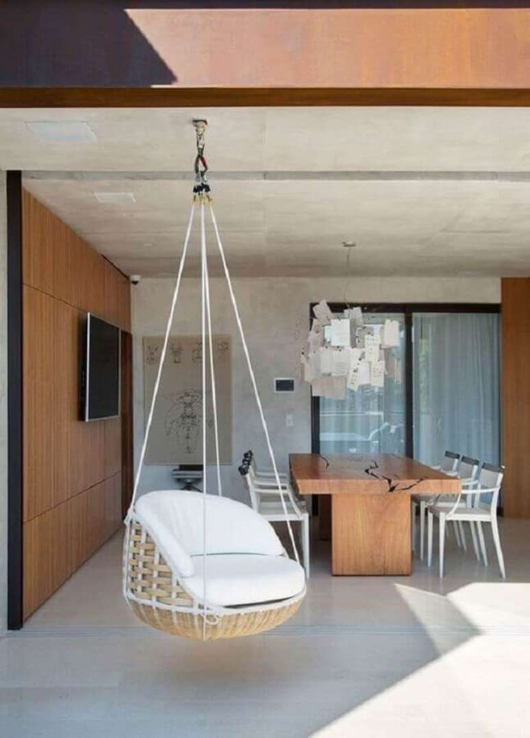 47. Decora&ccedil;&atilde;o com painel de madeira e cadeira de balan&ccedil;o suspensa para varanda gourmet grande &ndash; Foto: Casa de Valentina