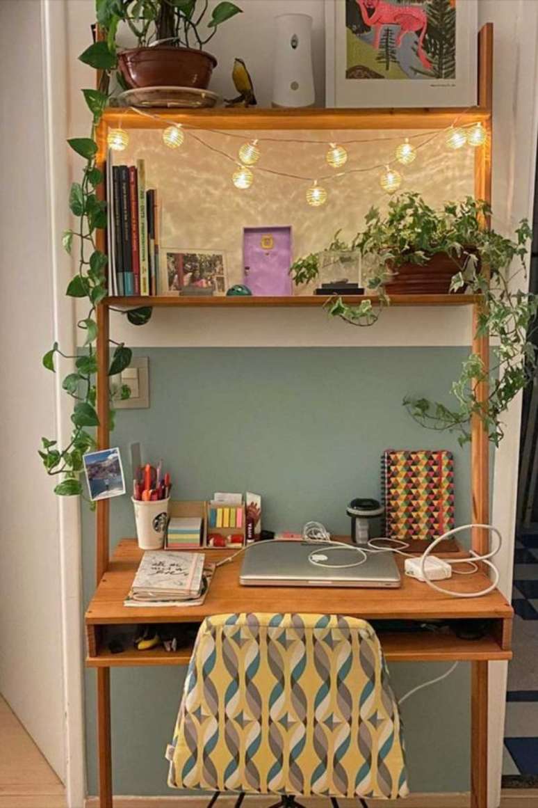 26. Home office na sala com estante de madeira – Foto Tadah Design