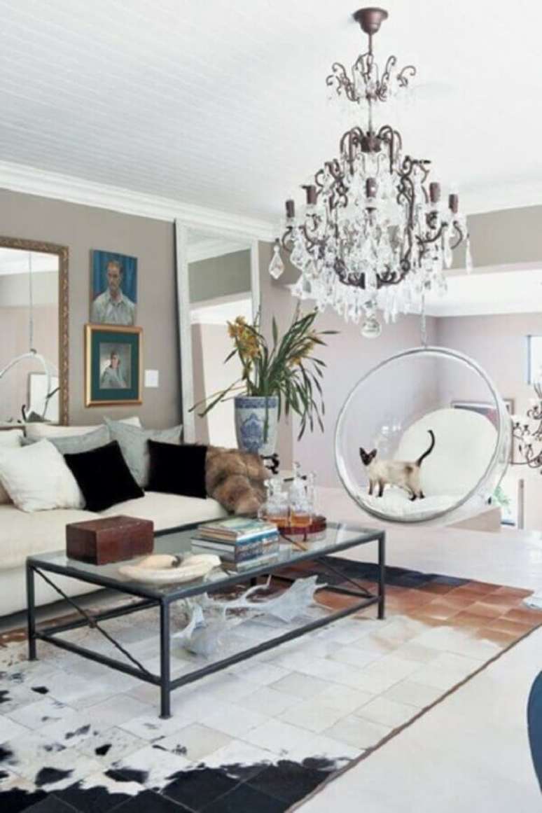 61. Sala de estar decorada com tapete de couro e cadeira de balanço moderna suspensa – Foto: Fashionismo