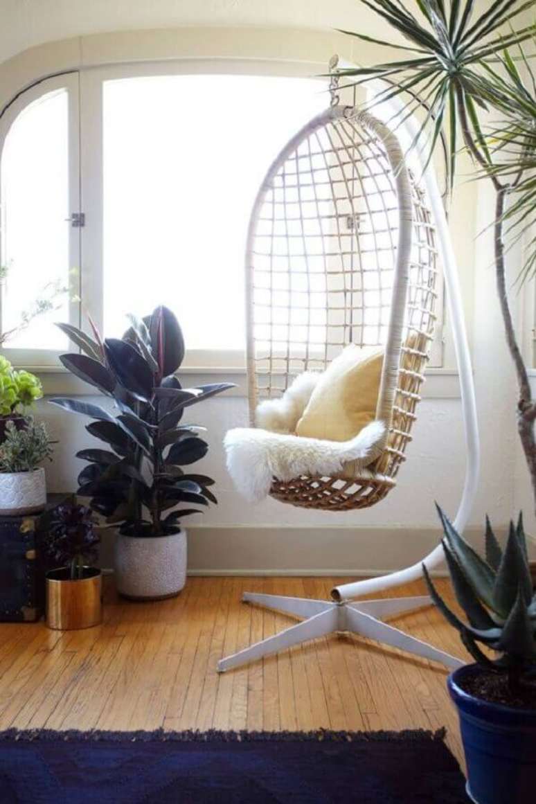 49. Decoração de sala com vasos de plantas e cadeira de balanço suspensa com suporte – Foto: Pinterest