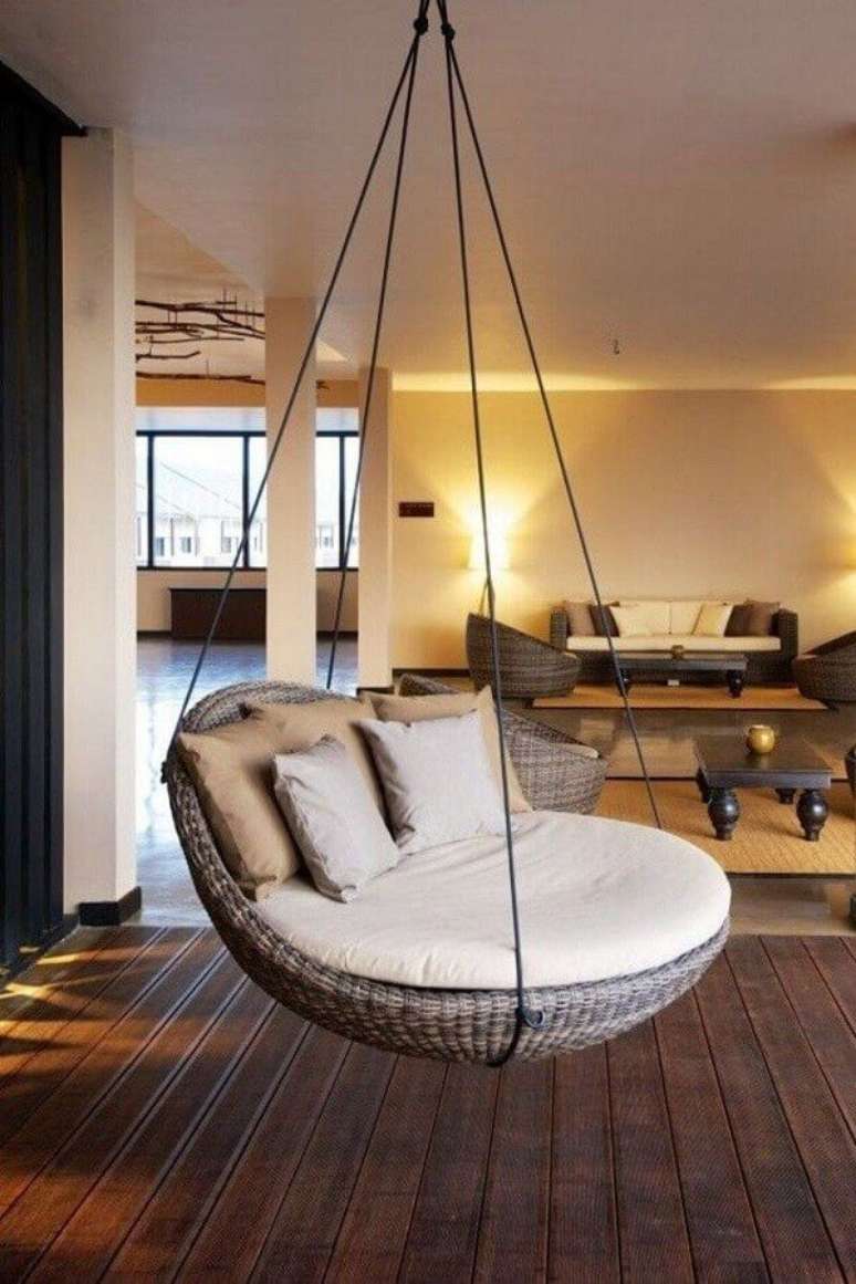 27. Cadeira de balanço suspensa para sala grande decorada com piso de madeira – Foto: Côté Maison